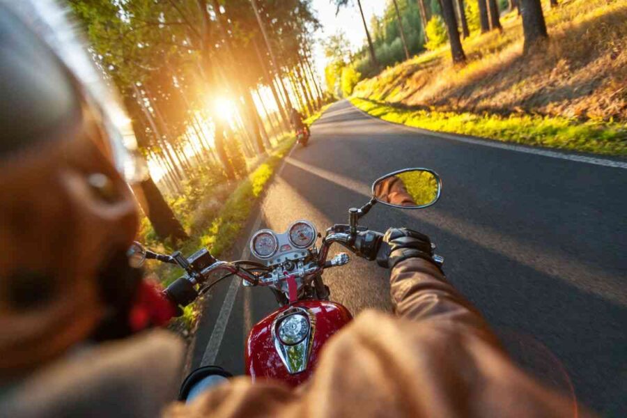 Motociclista su strada di campagna