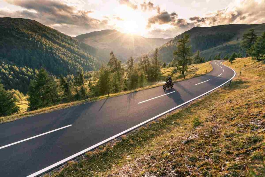 Motociclista su strada di montagna